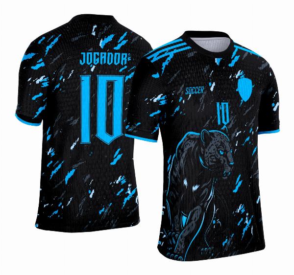 Camisa esportiva personalizada com design exclusivo, apresentando uma estampa gráfica detalhada na parte frontal, incorporando elementos artísticos como animais ou símbolos. O modelo inclui cores vibrantes e contrastantes, com detalhes adicionais como textos estilizados em diferentes idiomas. Na parte traseira, estão disponíveis personalizações com nome e número em destaque. Perfeita para jogos de interclasse, times amadores ou eventos esportivos personalizados.